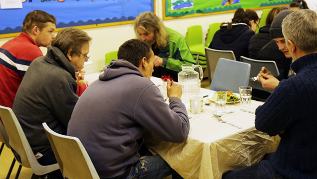 photo of floating shelter guests and leaders eating dinner and chatting